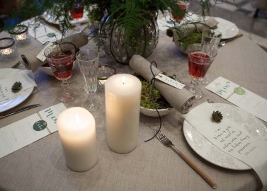 Hochzeitswahn - Ein festliches Abendessen mit brennenden Kerzen, frischem Grün und elegantem Geschirr, begleitet von personalisierten Namenskarten, heißt die Gäste zu einer warmen, intimen Feier willkommen.