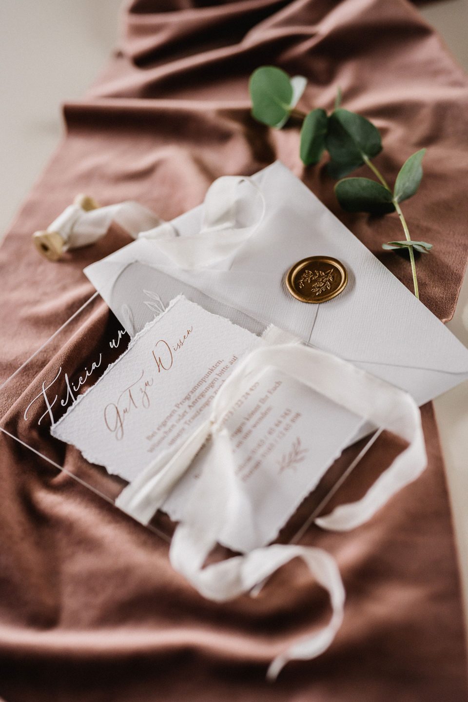 Hochzeitswahn - Elegantes Hochzeitseinladungsset auf staubrosa Stoff, einschließlich Kalligrafiekarten, einem Wachssiegel und grünen Eukalyptus-Akzenten. Magical-Homes