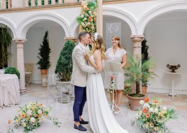 Hochzeitswahn - Ein Mann und eine Frau küssen sich in einem Innenhof.