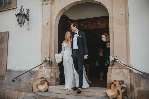 Hochzeitswahn - Eine Braut und ein Bräutigam gehen die Stufen einer Kirche hinunter.