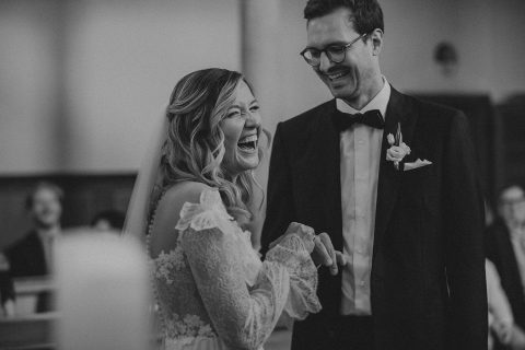 Hochzeitswahn - Eine Braut und ein Bräutigam lachen während ihrer Hochzeitszeremonie.