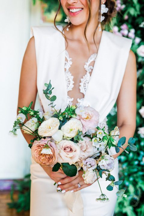 Hochzeitswahn - Eine Braut in einem weißen Kleid hält einen Blumenstrauß.