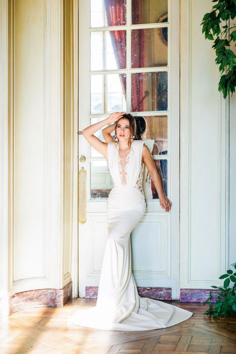 Hochzeitswahn - Eine Braut in einem weißen Hochzeitskleid posiert vor einer Tür.